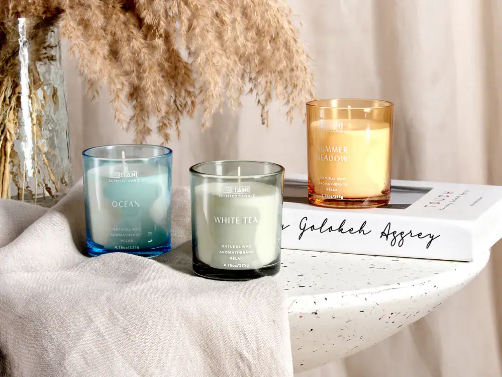 مجموعة من الشموع الطبيعية المضاءة في أوعية زجاجية أنيقة داخل غرفة معيشة