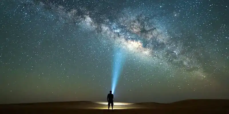 منظر للسماء ليلًا تظهر فيه مجرة درب التبانة والنجوم اللامعة.