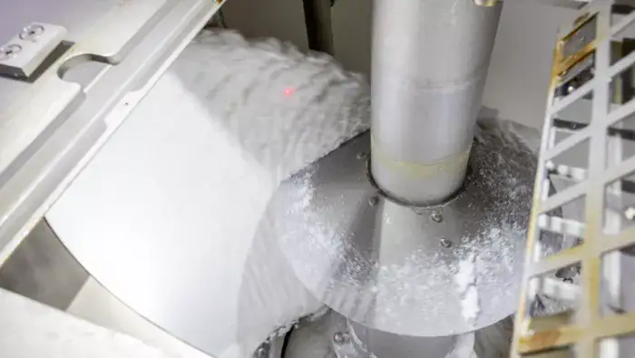 عملية فصل دبس السكر عن بلورات السكر الأبيض في جهاز طرد مركزي.