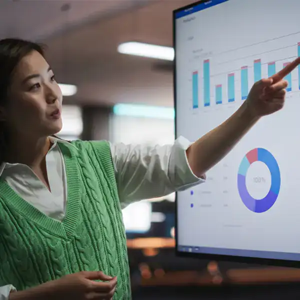 طالب يجلس أمام شاشة كمبيوتر تعرض رسومًا بيانية معقدة لتحليل البيانات