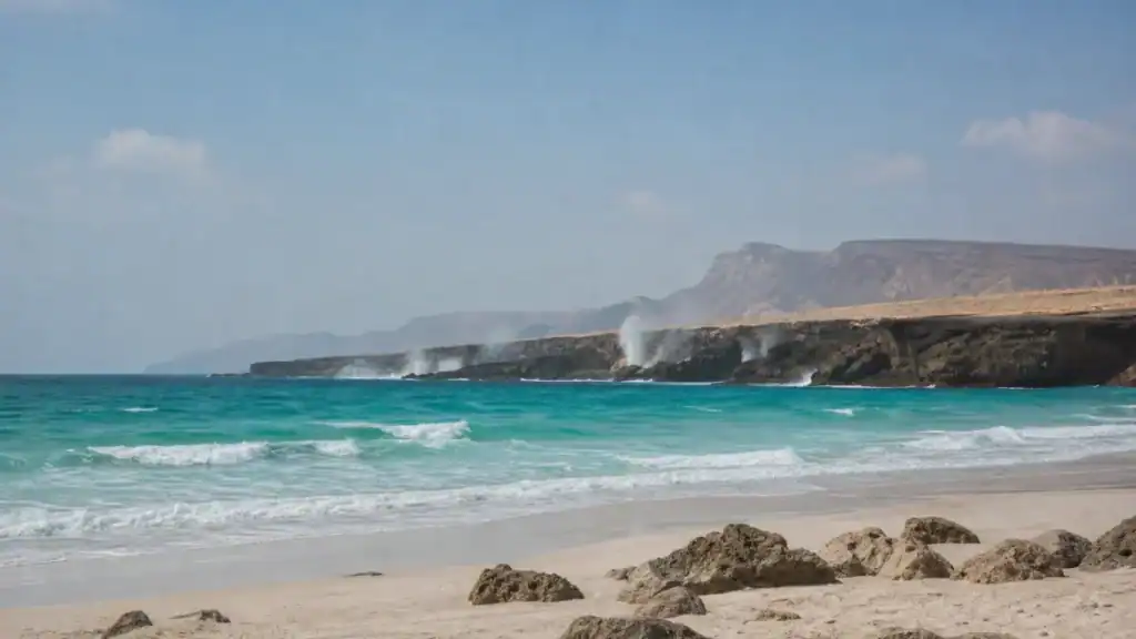 شاطئ المغسيل في ظفار بعناصره الصخرية ورماله الفاتحة ومياه بحر العرب.